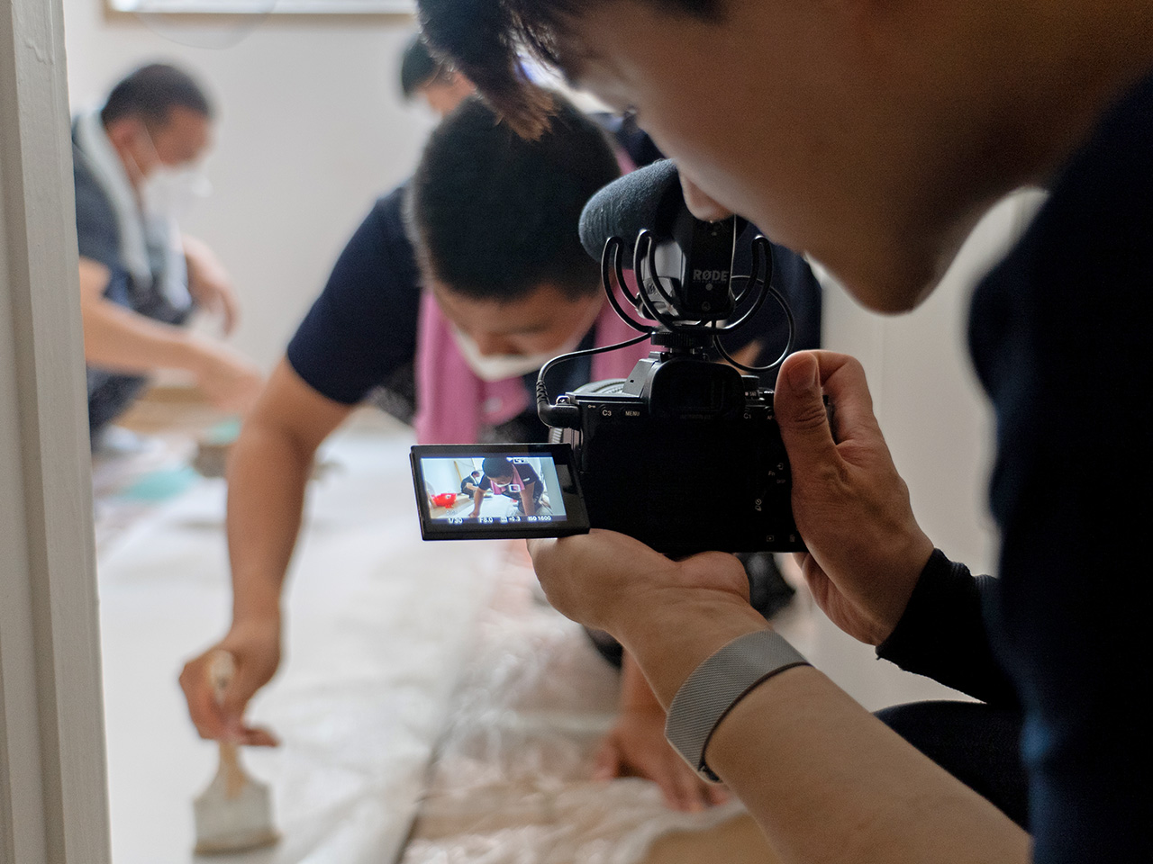 카메라로 페인트 칠하는 사람들을 촬영하는 클로즈업 사진