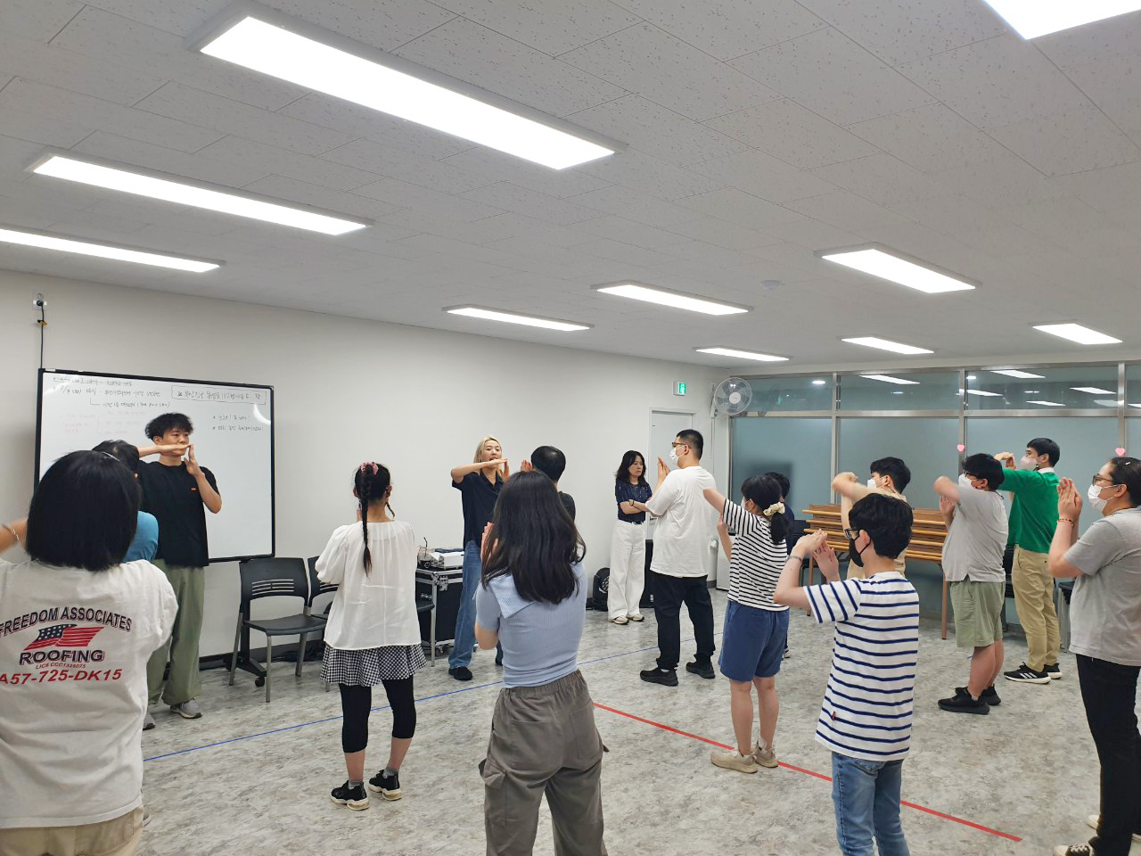 여러 사람이 실내에서 함께 스트레칭 또는 율동을 하는 모습