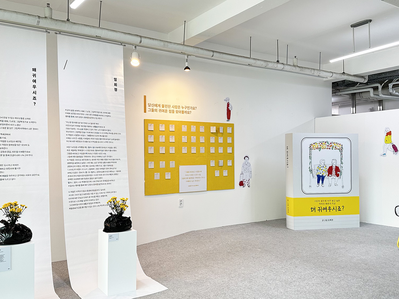 노란색 벽과 흰색 가벽으로 구성된 전시 공간에 작품들이 전시된 모습